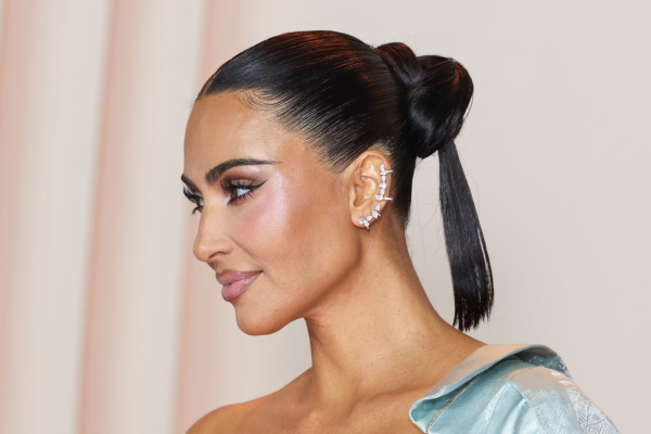 Kim Kardashian appears on the red carpet in a blue gown and sleek updo.